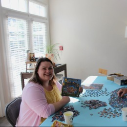 woman sitting at a table doing a puzzle