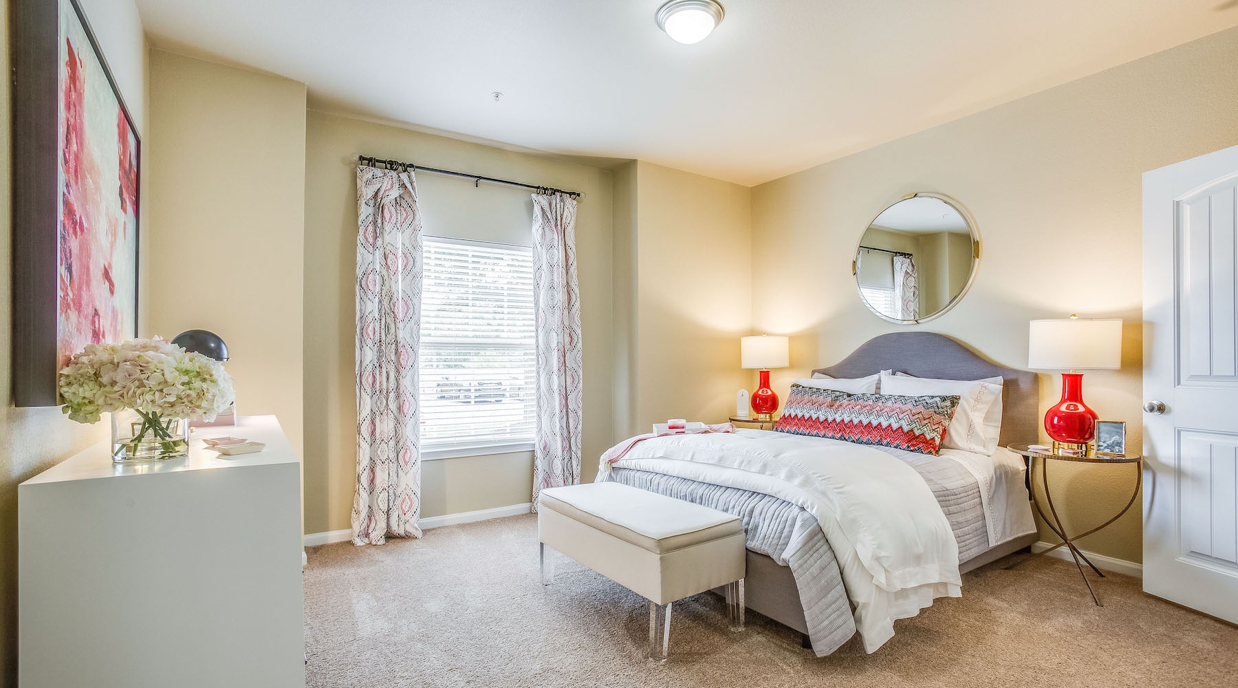 Large well lit bedroom with wood floors 