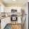 Spacious and well lit kitchen with wood flooring and stainless steel appliances