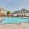 Large sparkling blue pool with a large pool deck and lounge chairs