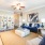 Spacious and well lit living room with wood flooring, large windows and open access to the kitchen